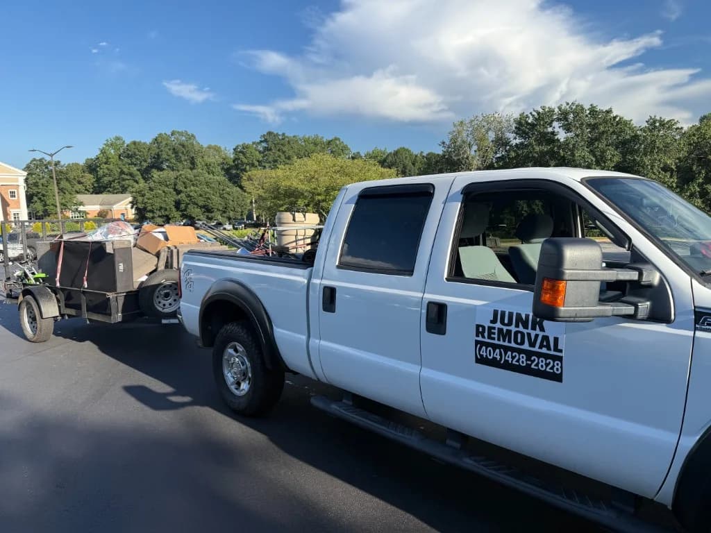 Famous Hauling & Service truck towing a trailer loaded with furniture and boxes